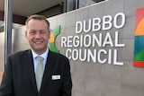Ben Shields, Dubbo Mayor, standing in front of city council sign