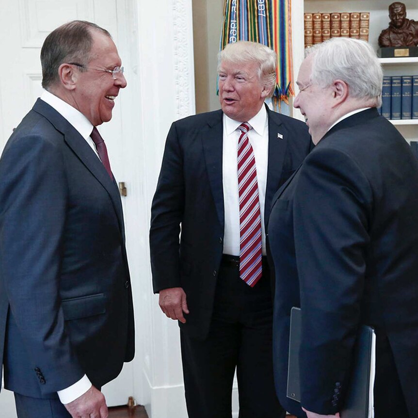 Donald Trump stands in the centre of the white house talking to Sergey Lavrov and Sergei Kislyak
