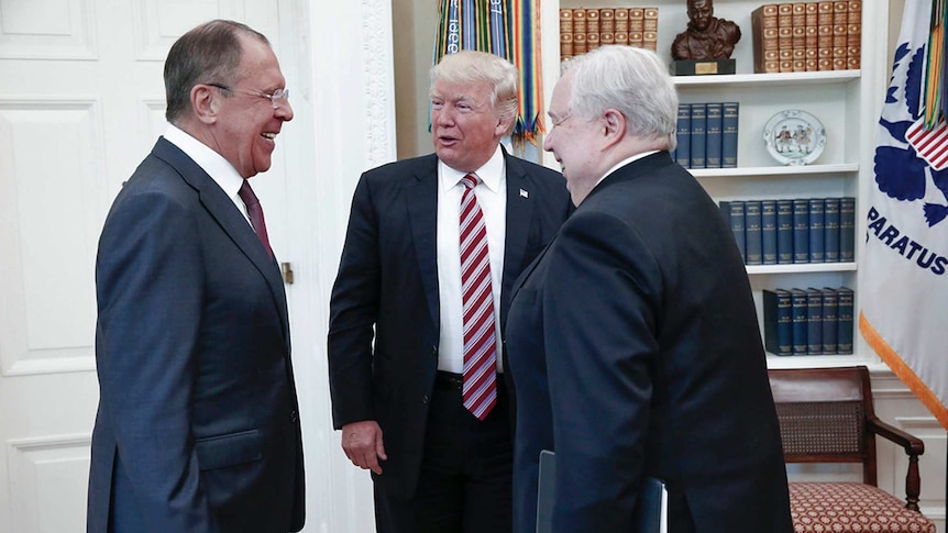 Donald Trump stands in the centre of the white house talking to Sergey Lavrov and Sergei Kislyak