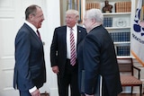 Donald Trump stands in the centre of the white house talking to Sergei Lavrov and Sergey Kislyak