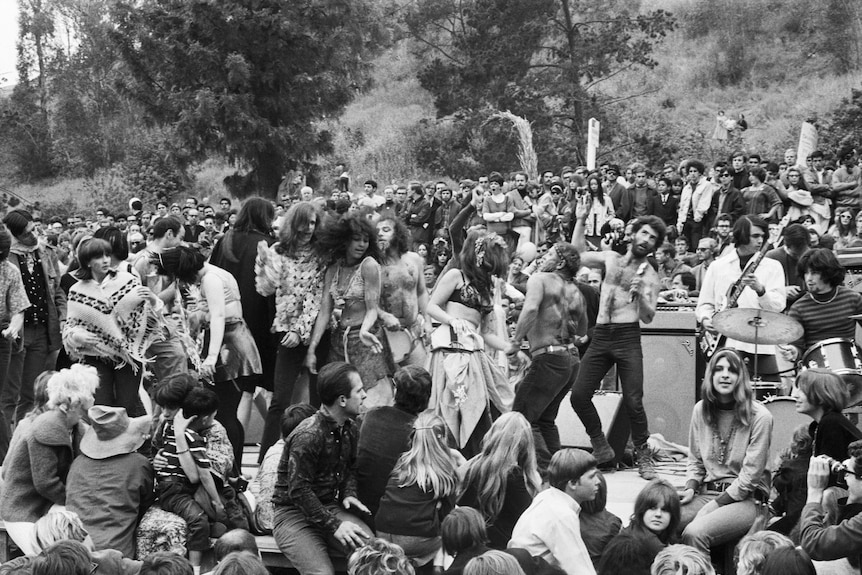 A black and white image of a crowd at a sixties love-in