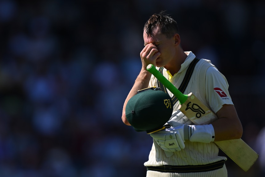 Marnus Labuschagne holds the bridge of his nose in frustration while walking off the field