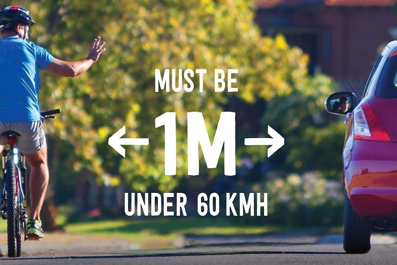 An advertisement reading 'Must be 1m under 60kmh' shows a rear view of a cyclist acknowledging a driver as they pass.