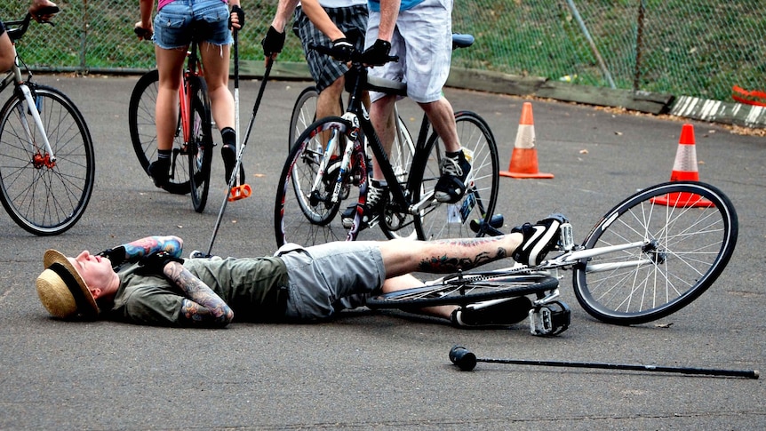 A player lies on the ground after falling off his bike