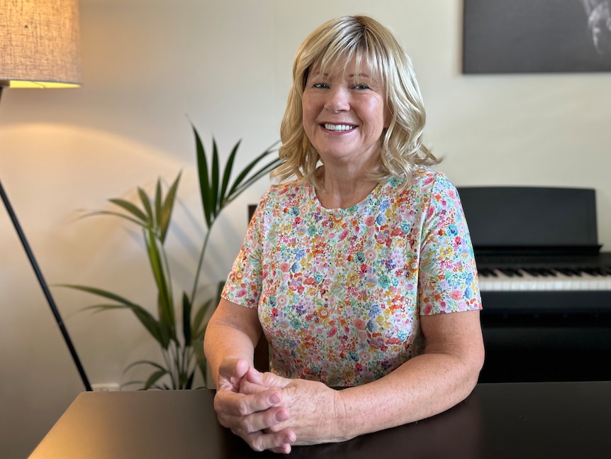 Smiling blonde woman wearig flowery blouse 