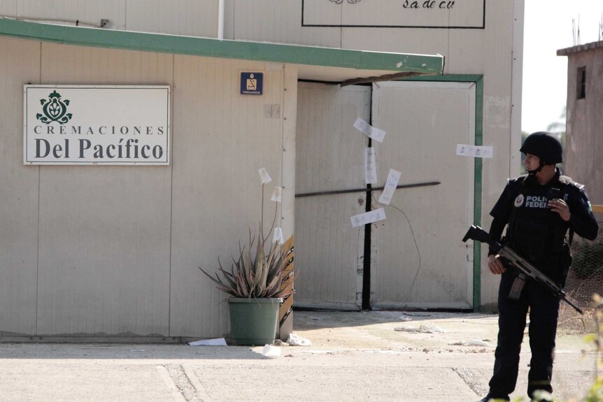 A police officer stands guards outside a sealed-off private crematorium in Mexico.