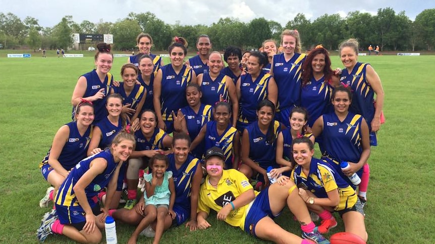 A group of women in football uniforms on an sports oval.