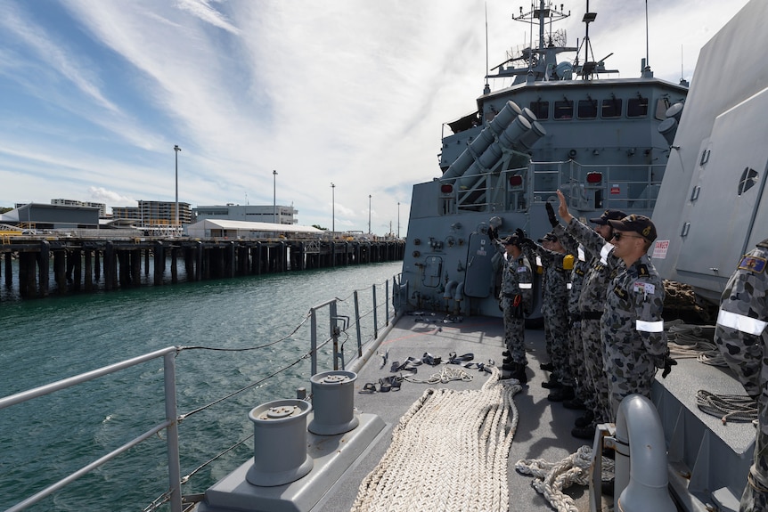 HMAS Parramatta crew members wave goodbye as they depart Fort Hill Wharf in Darwin, Northern Territory.