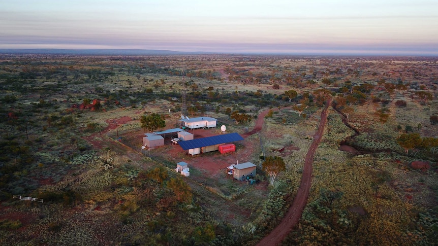 Aerial shot of a few buildings in the middle of the outback as the sun goes down