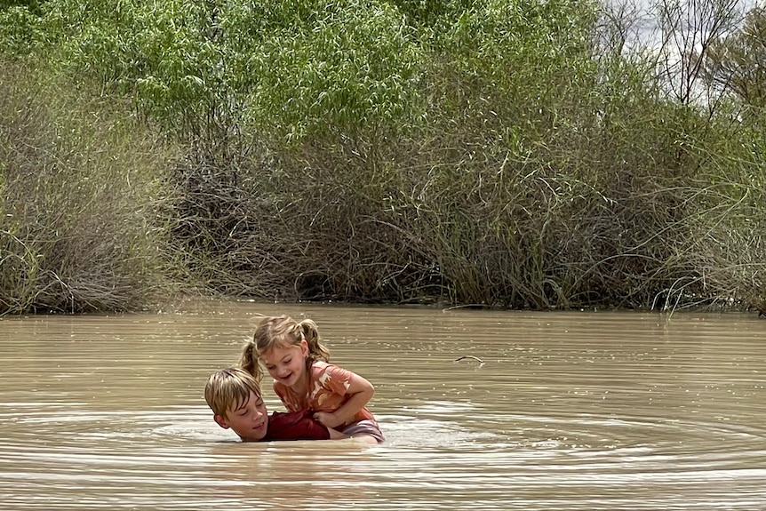 Boy and girl playing in pond