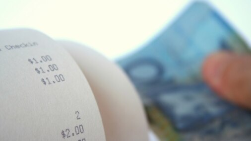 Close-up of a bill and an out of focus hand holding a $10 note [Thinkstock: iStockphoto]