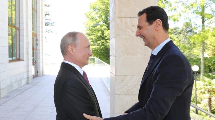 Russian President Vladimir Putin welcomes a laughing Syrian President Bashar al-Assad