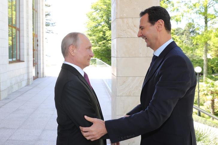 Russian President Vladimir Putin welcomes a laughing Syrian President Bashar al-Assad