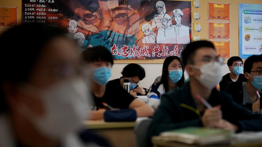 Chinese students wearing face masks are seen inside a classroom.