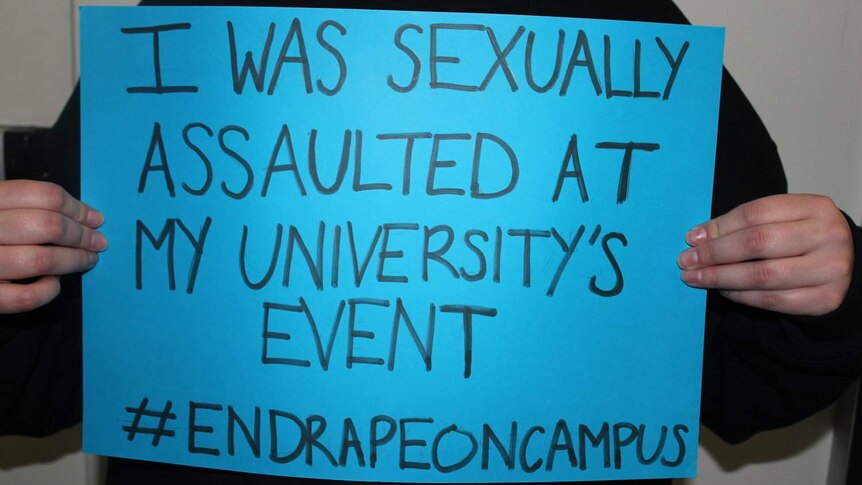 Blue placard says: I was sexually assaulted at my university's event #endrapeoncampus