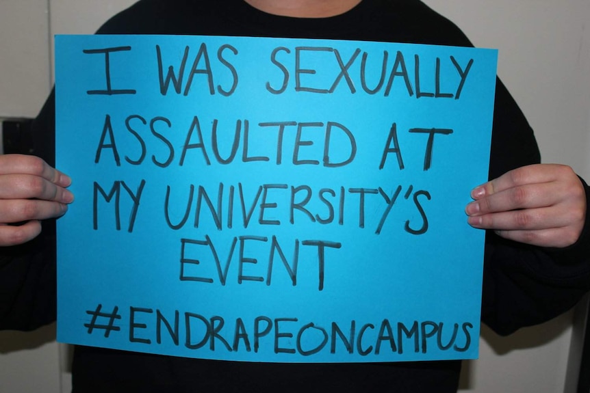 Blue placard says: I was sexually assaulted at my university's event #endrapeoncampus