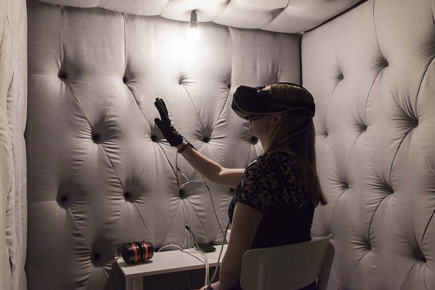 The artist Eugenie Lee invites you into a padded room, she has a glove and VR headset on