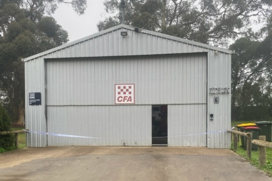Photo shows exterior of Woodstock West fire station. There is police tape around a tin shed with a red CFA logo in the middle.  