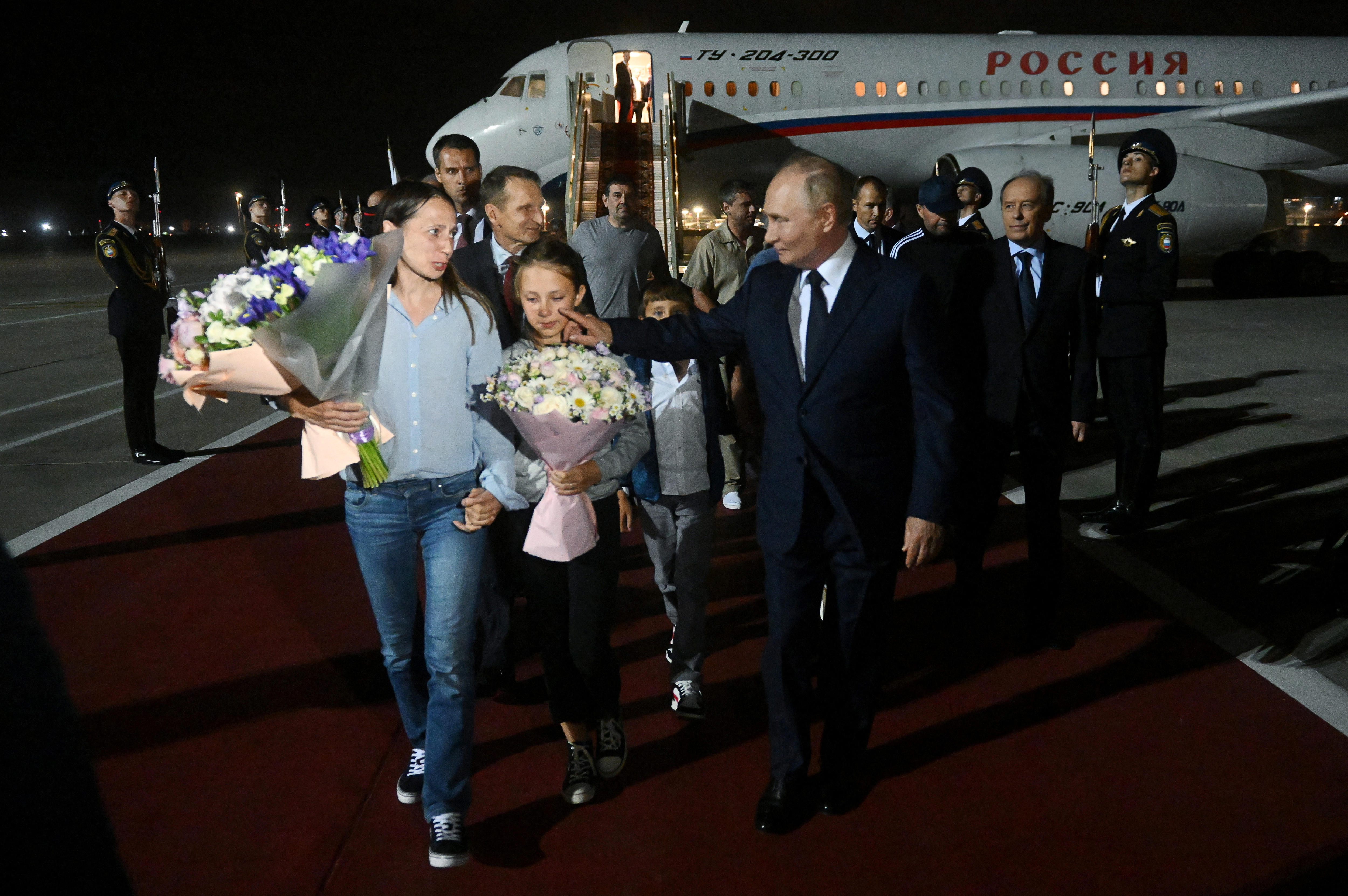 Putin reaches over to touch Dultseva's daughter's face.