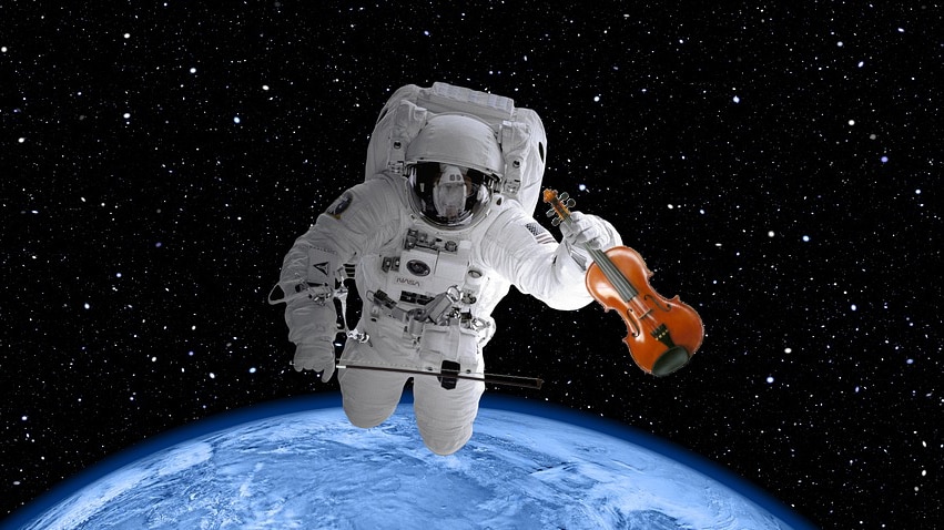 An astronaut floats in space holding a violin.