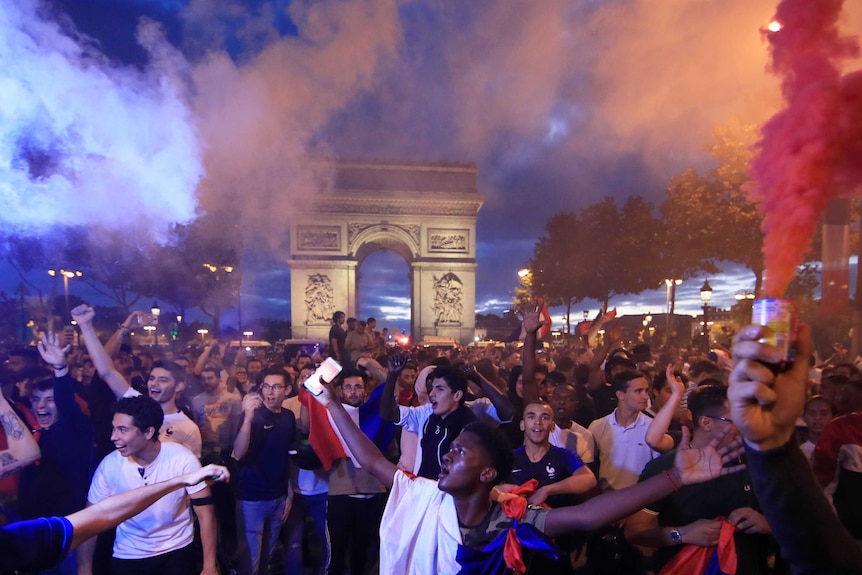 French fans celebrate in front of the Arc de Triomphe
