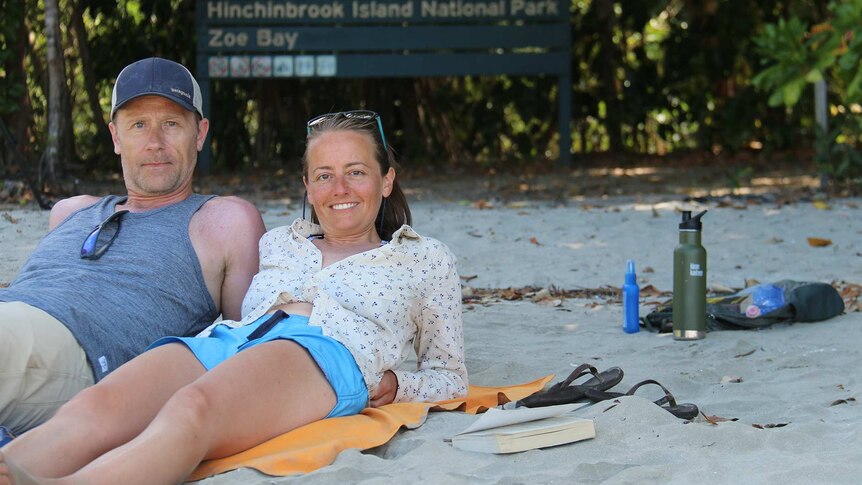 Tamie and Eddie Cleaver lay on the beach near a sign of Zoe Bay on Hinchinbrook Island off north Queensland.