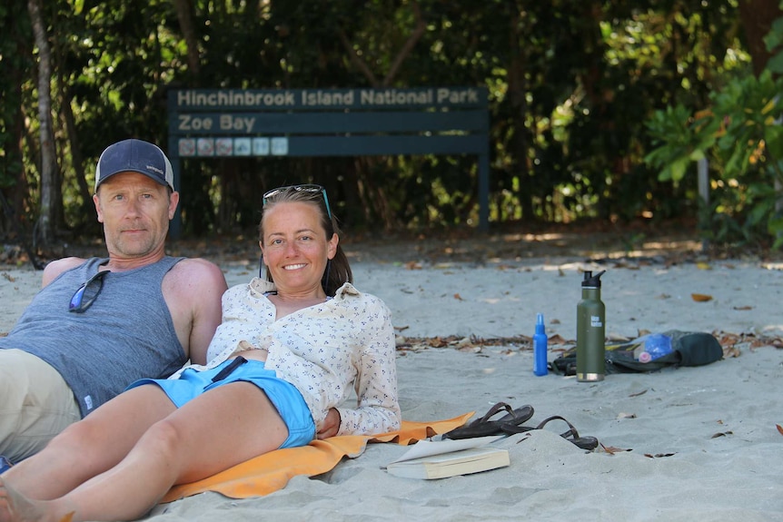 Tamie and Eddie Cleaver lay on the beach near a sign of Zoe Bay on Hinchinbrook Island off north Queensland.