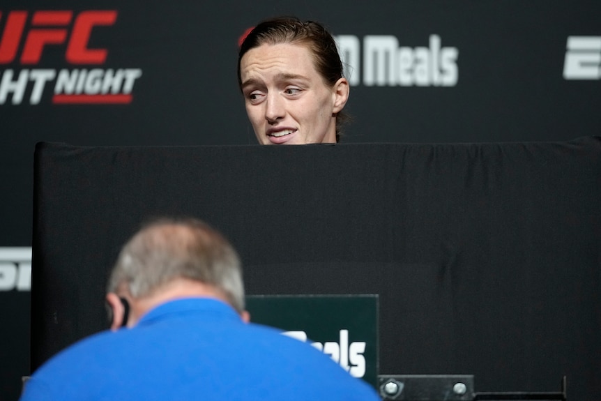 UFC fight Aspen Ladd's head is visible over the top of a privacy shield as she weighs in.