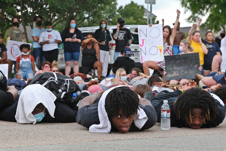 Demonstrators lie face down depicting George Floyd during his detention by police, at the Norman Police Department Tuesday