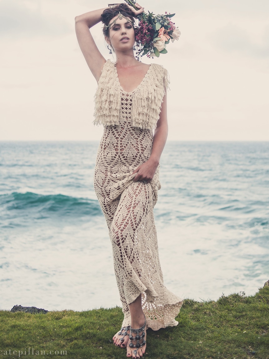 Bride poses in crocheted wedding gown