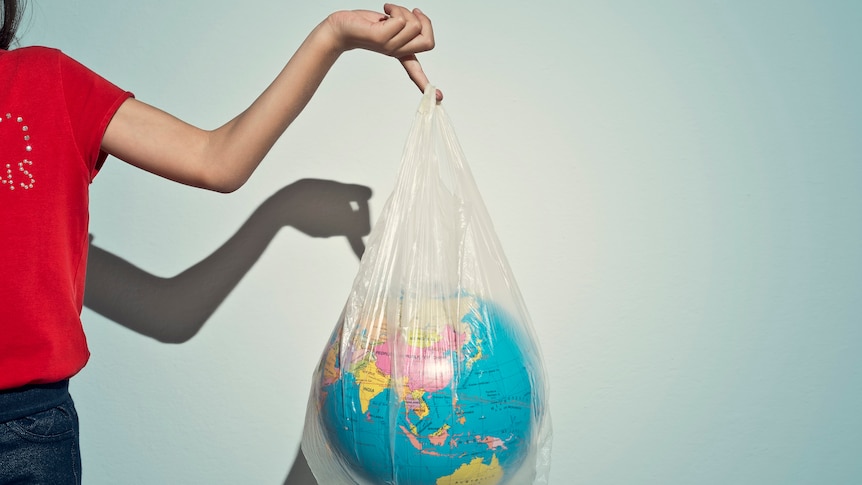Woman holding a plastic bag with a globe inside