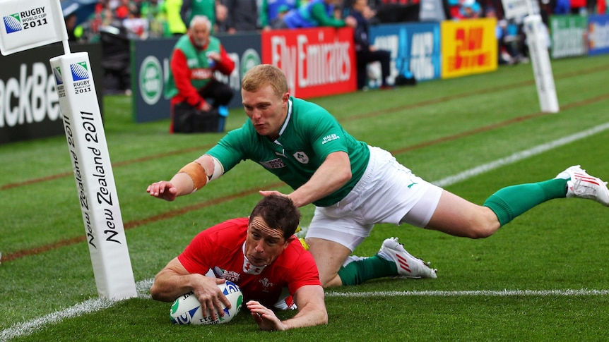 Danger out wide ... Shane Williams dives across for a Wales try under pressure from Keith Earls.