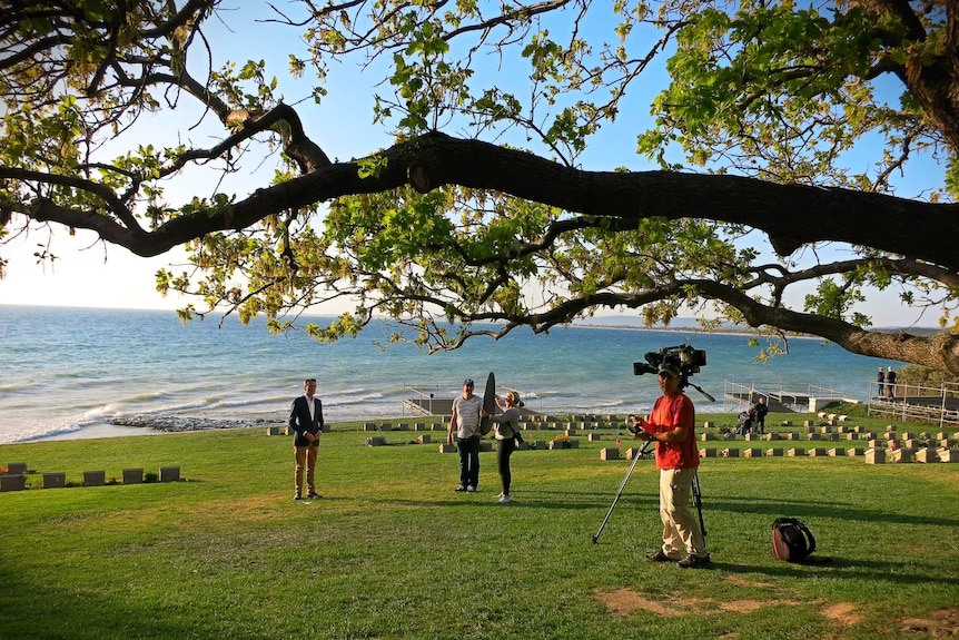 Rowland and crew filming in cemetery by the sea under beautiful huge tree branch.