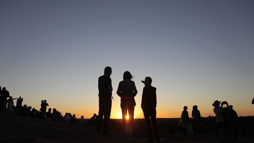 Festival goers head to wave rock as the sun sets