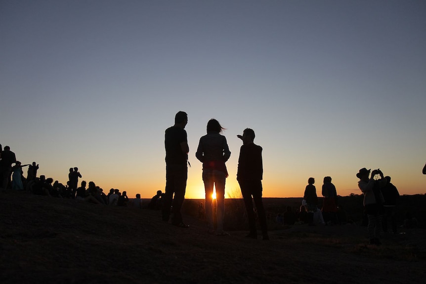 Festival goers head to wave rock as the sun sets