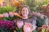 Florist Justine Ellborn surrounded by flowers in a story about why it's hard to buy flowers during coronavirus pandemic.