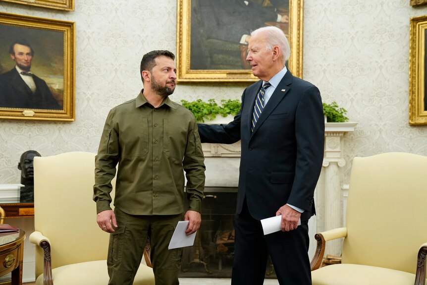 A man in military greens, with an older man in a suit, in the White House