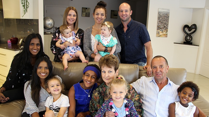 A large multicultural blended family in a lounge room.