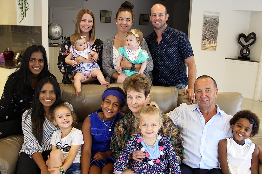 A large multicultural blended family in a lounge room.