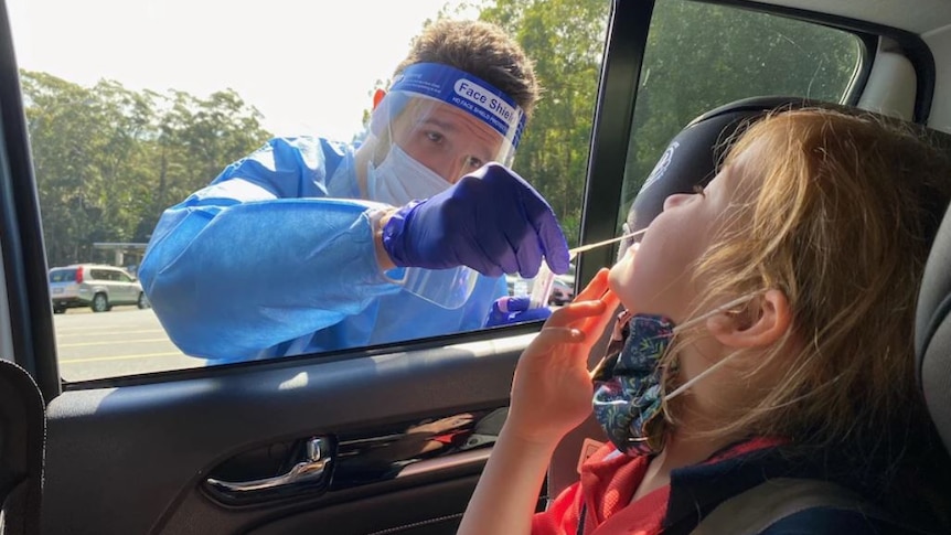 A child in a car receives a COVID nasal swab