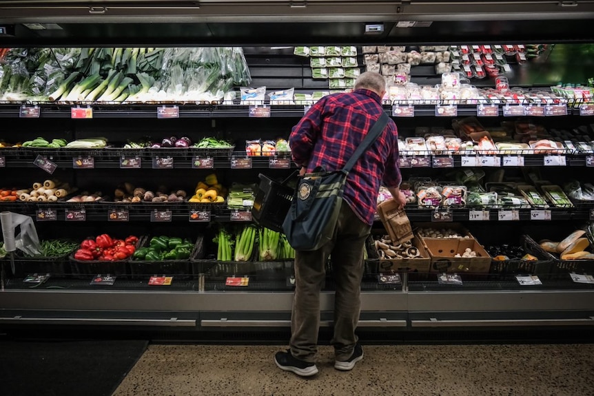 Paul Smith grocery shopping in the vegetable section of the supermarket