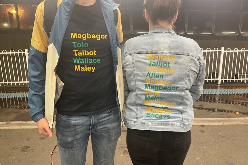 Two people (heads cropped) wear jackets with the names of Australian Opals players including Magbegor, Tolo, Talbot, Wallace