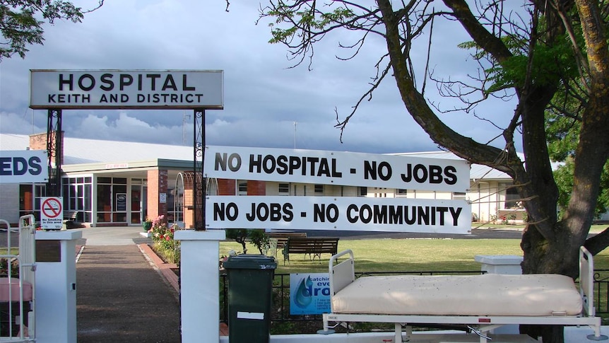 Signs outside a hospital saying No hospital, no jobs, no community