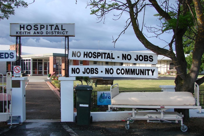 Signs outside a hospital saying No hospital, no jobs, no community