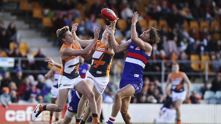The Bulldogs' Ryan Griffen and GWS' Jeremy Cameron and Lachie Whitfield contest the ball at Manuka.