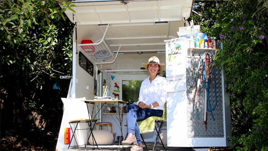 Sam Tassini sits in her horse float she has converted into her office.