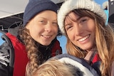 Greta Thunberg, baby Lenny Whitelum and Elayna Carausu take a selfie on the deck of a boat at sea.