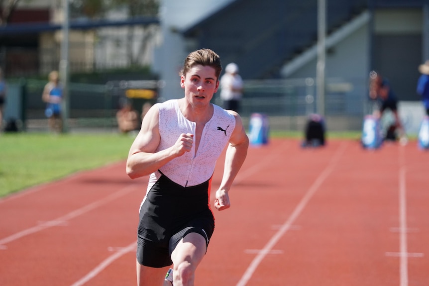 A man running down an athletics track