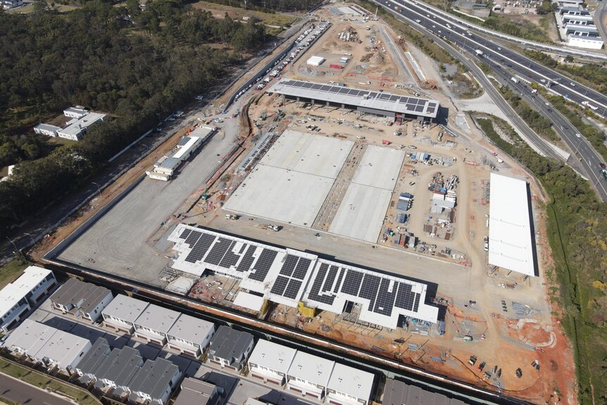 An aerial image of a construction site, with two buildings and several concrete slabs.