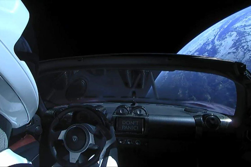 A view shows a Tesla Roadster in space.